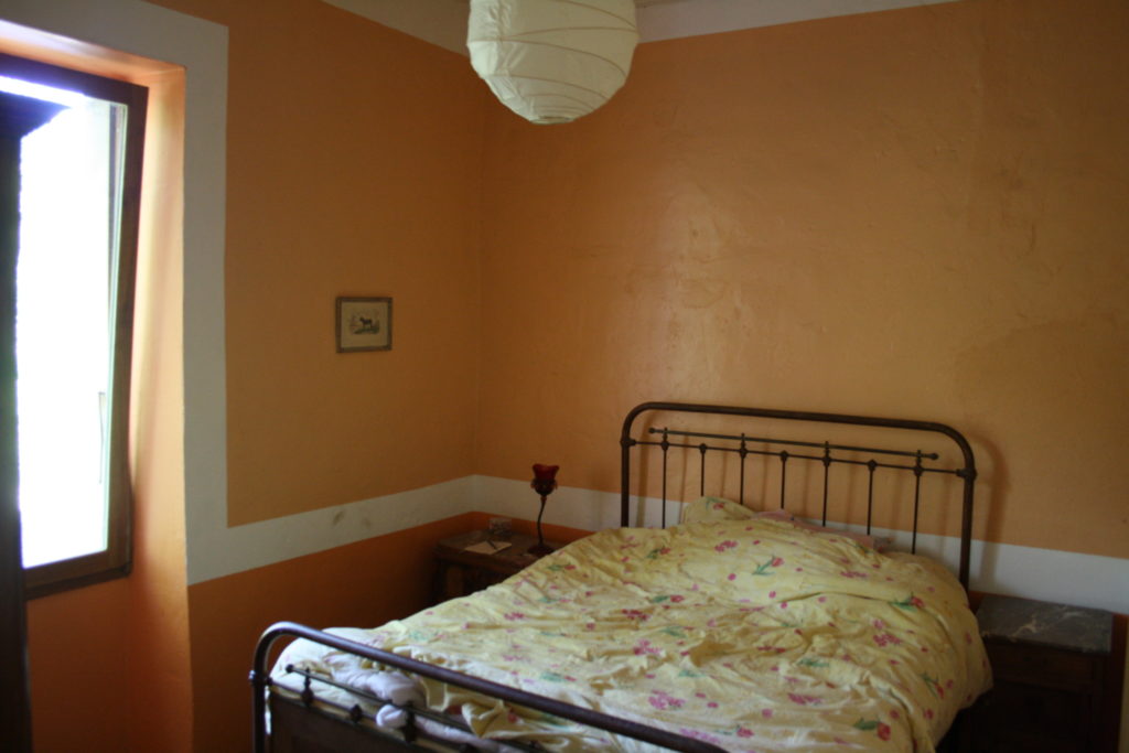 Chambre aux murs ocres et lit double